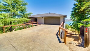 A house with a garage, a concrete driveway, and a wooden fence. - Idyllic Kelseyville Home w/ 2 Decks + Views! (Kelseyville)