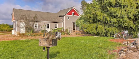 A house with a red roof, a mailbox, and a bicycle in the yard.