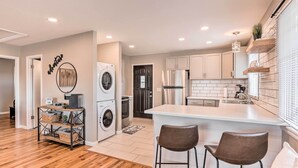 A modern kitchen with a central island, stainless steel appliances, and a built-in oven.
