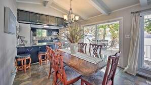 A dining area with a wooden table, chairs, and a chandelier.