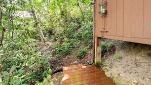 A wooden deck leading to a building with a metal railing and a green water dispenser. - Lakefront Butler Retreat w/ Hot Tub & Dock! (Butler)
