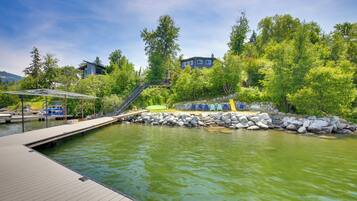 A wooden deck with a pool, surrounded by rocks and trees.