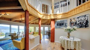 Ruime binnenruimte met een houten plafond, een balkon en een eethoek met uitzicht op de omgeving.