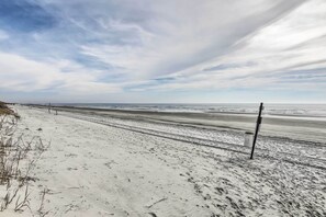 A wide, sandy beach with a clear sky and distant horizon. - Freshly Remodeled Beach House, Steps to Shore (Sunset Beach)