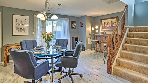 A dining area with a round table, chairs, and a chandelier.