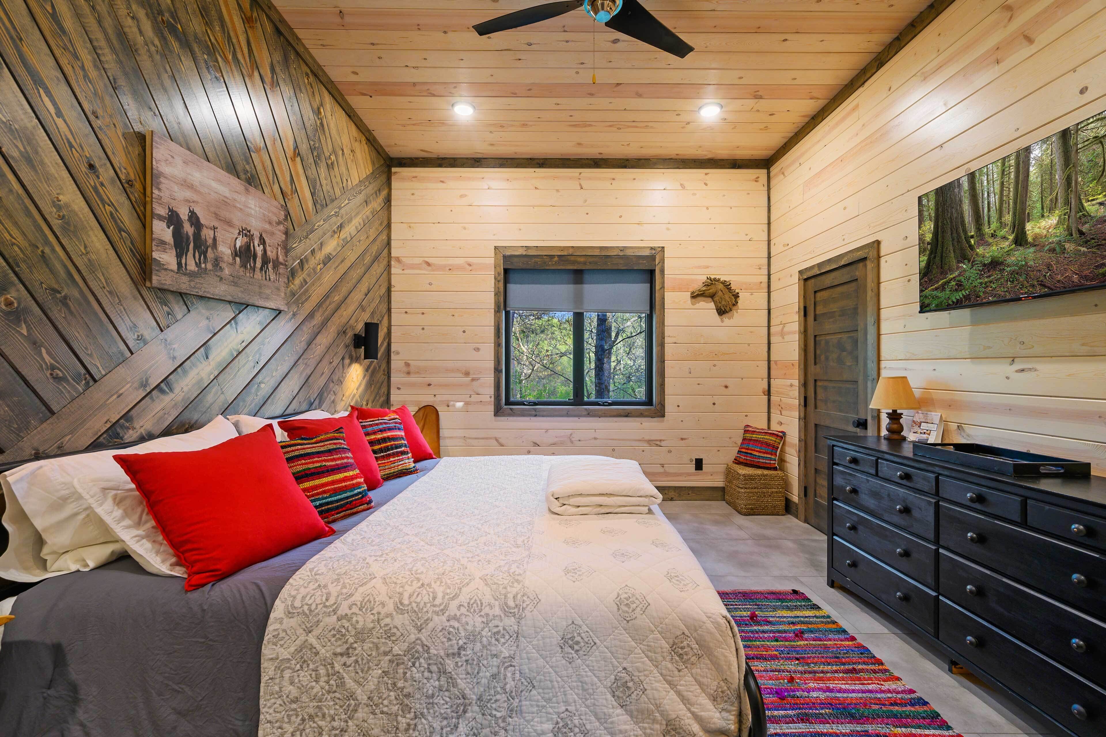 Un dormitorio con una cama, un aparador, una ventana y un cuadro en la pared.