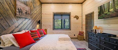 Un dormitorio con una cama, un aparador, una ventana y un cuadro en la pared.
