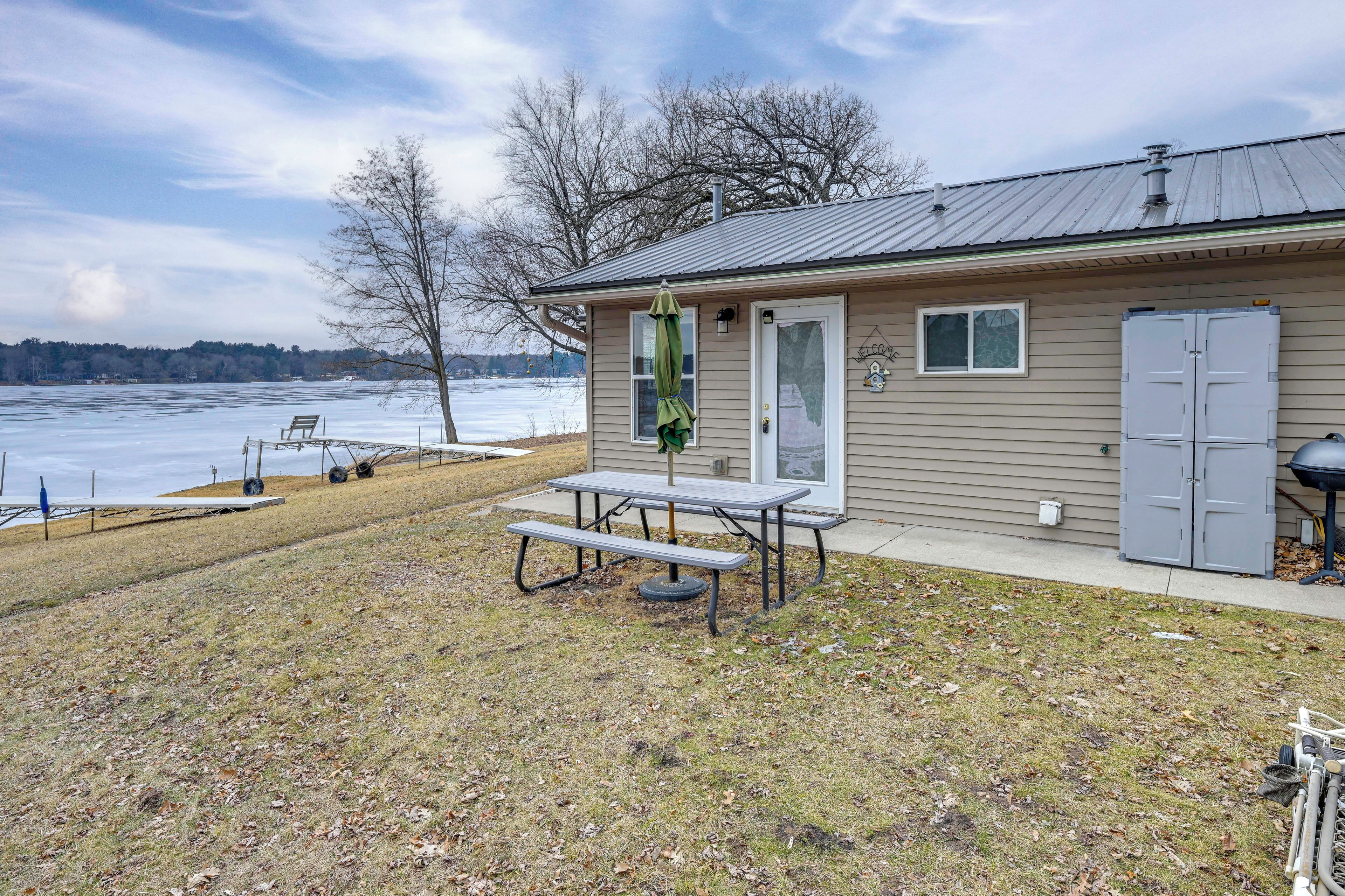 A house with a picnic table and a shed.