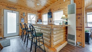 L’intérieur d’une cabine comprenant un coin bar, des murs en bois et un ventilateur de plafond.