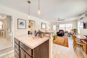 A modern kitchen with a granite countertop, a dining area with a wooden table and chairs, and a living room with a sofa and a coffee table. - Maine Cottage w/ Dock & Kayaks, Near Augusta! (Augusta)