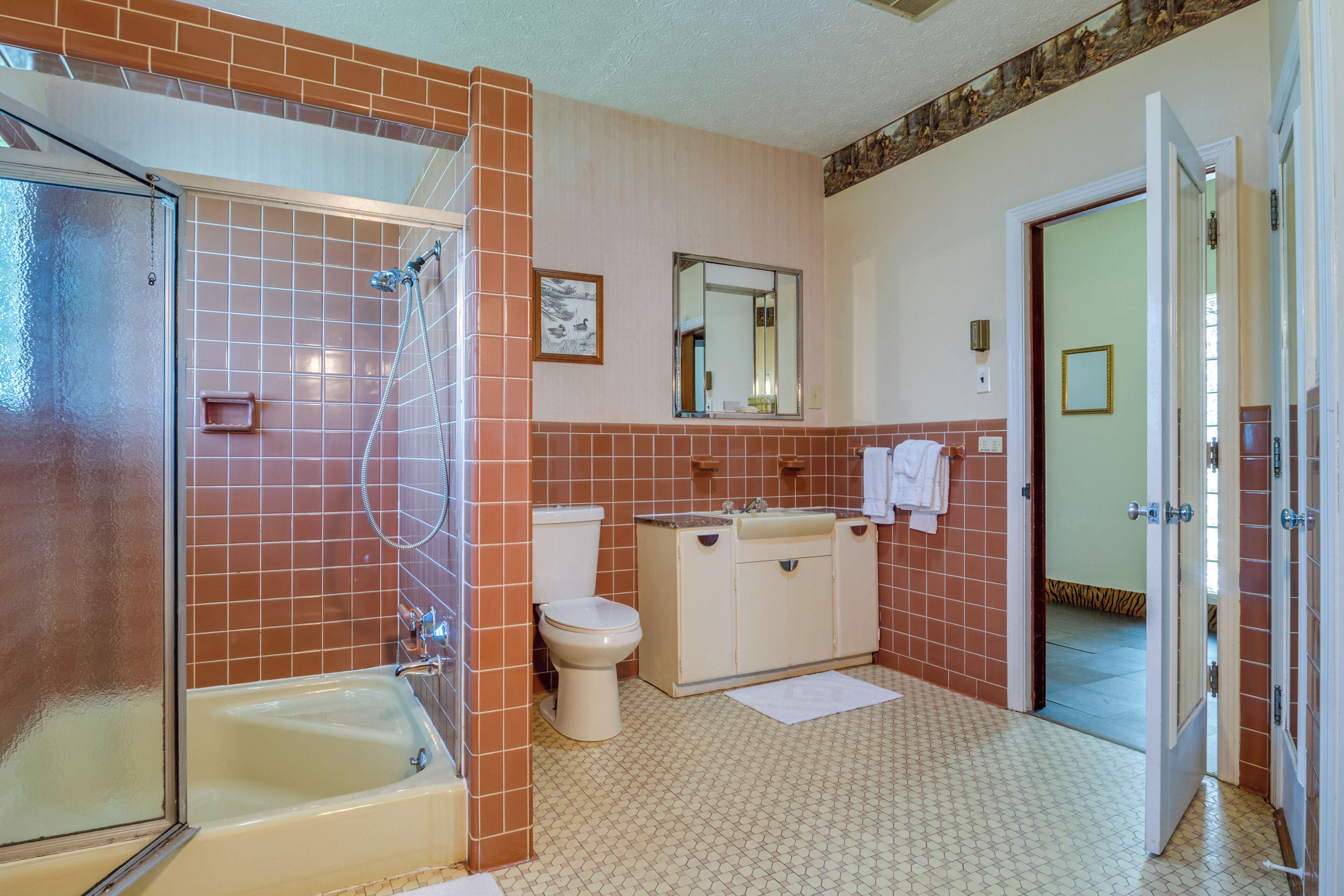 A bathroom with a bathtub, toilet, and sink.