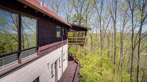 A wooden cabin with large windows and a deck overlooking a forest. - 'ledge Lodge' Burkesville Getaway: Pool & Views! (Burkesville)