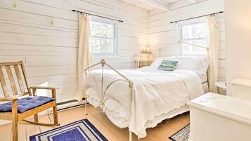 A bedroom with a bed, a rocking chair, and a nightstand.