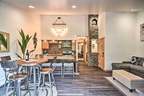 Une cuisine moderne dotée d’un îlot central, de tabourets de bar et d’une table à manger avec des chaises.