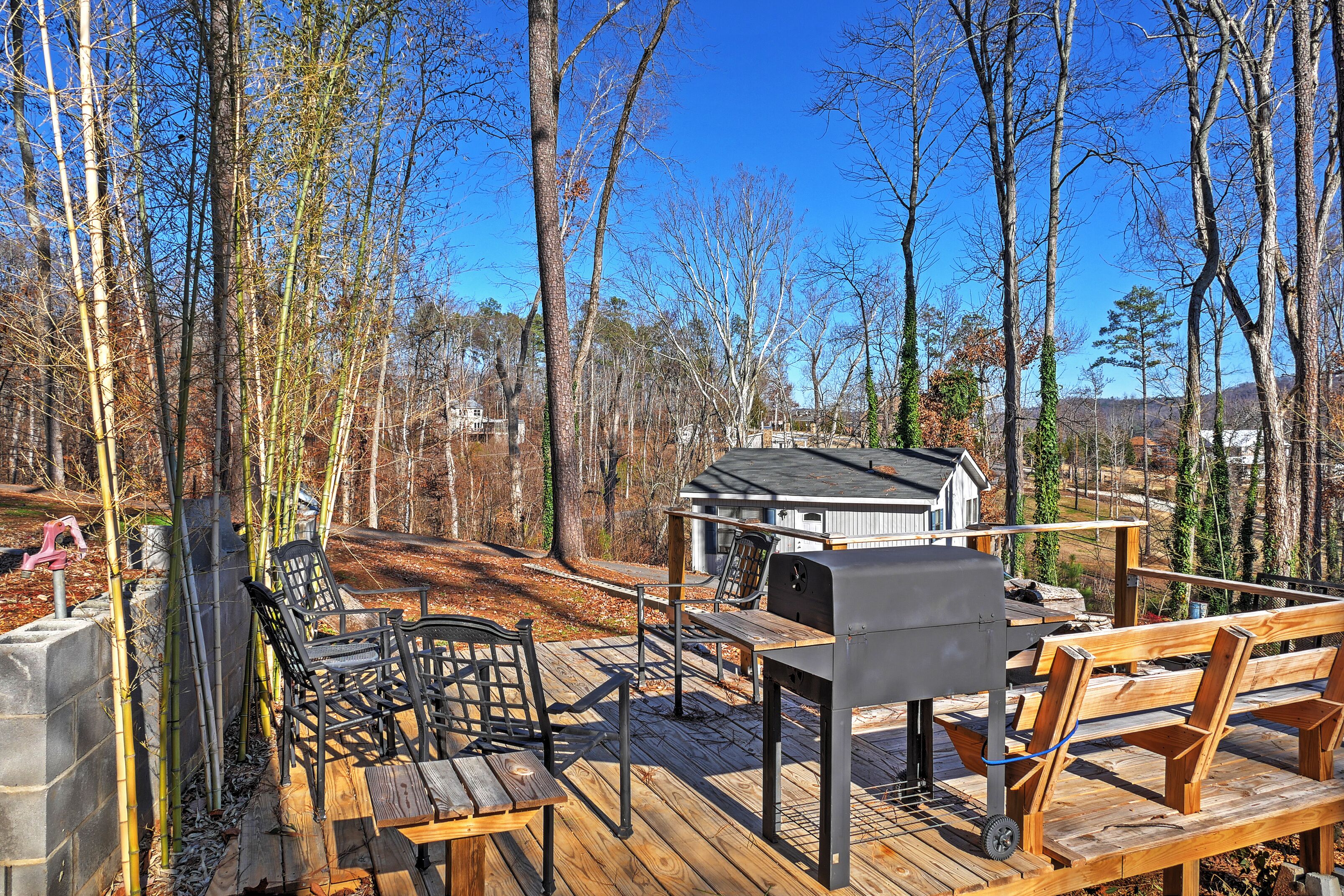 A deck with outdoor furniture, a grill, and a small shed.
