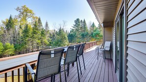 A wooden deck with chairs and a table, overlooking a forested area. - Newcomb Retreat w/ Mountain Views & Fire Pit! (Newcomb)
