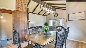 A dining area with a wooden table and chairs, a potted plant, and a wall with a framed quote. - Newcomb Retreat w/ Mountain Views & Fire Pit! (Newcomb)