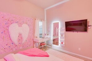 A pink-themed bedroom with a large white heart mural, a vanity with a mirror, and a flat-screen TV mounted on the wall. - Temple Retreat: Game Room & Deck, Pets Welcome (Temple)