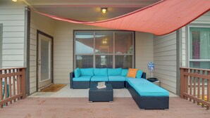 A covered outdoor seating area with a sectional sofa and ottoman, a small table, and a hammock. - Temple Retreat: Game Room & Deck, Pets Welcome (Temple)