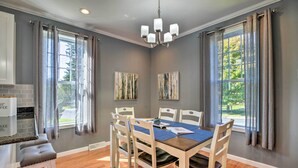 A dining area with a table set for four, surrounded by chairs, a chandelier, and artwork on the walls. - Quaint Ligonier Family Home - 3 Miles to Idlewild! (Ligonier)