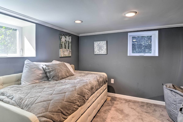 A bedroom with a bed, gray walls, a window, and two wall-mounted lights. - Quaint Ligonier Family Home - 3 Miles to Idlewild! (Ligonier)