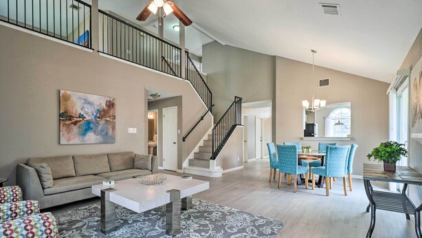 A spacious living area with a sofa, coffee table, patterned rug, and a dining area with chairs and a table. - Peaceful Austin Home w/ Private Backyard! (Austin)