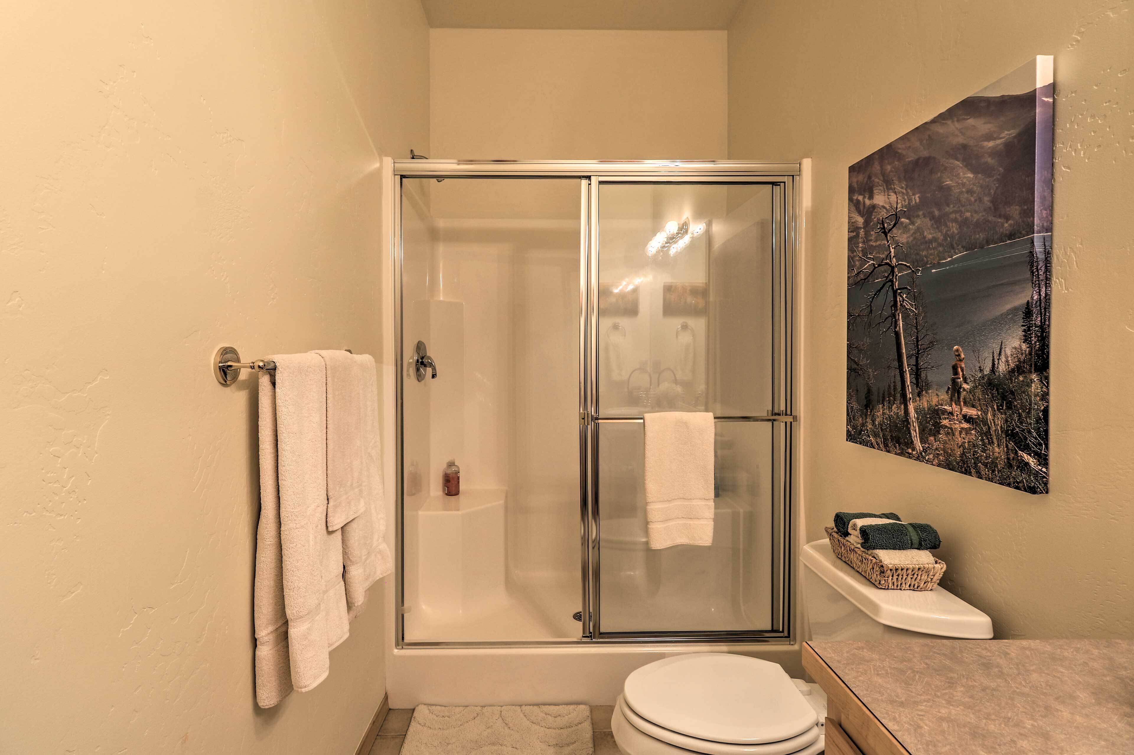 Un bagno con doccia vetrata, un water e un lavandino.