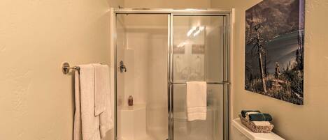 Un bagno con doccia vetrata, un water e un lavandino.