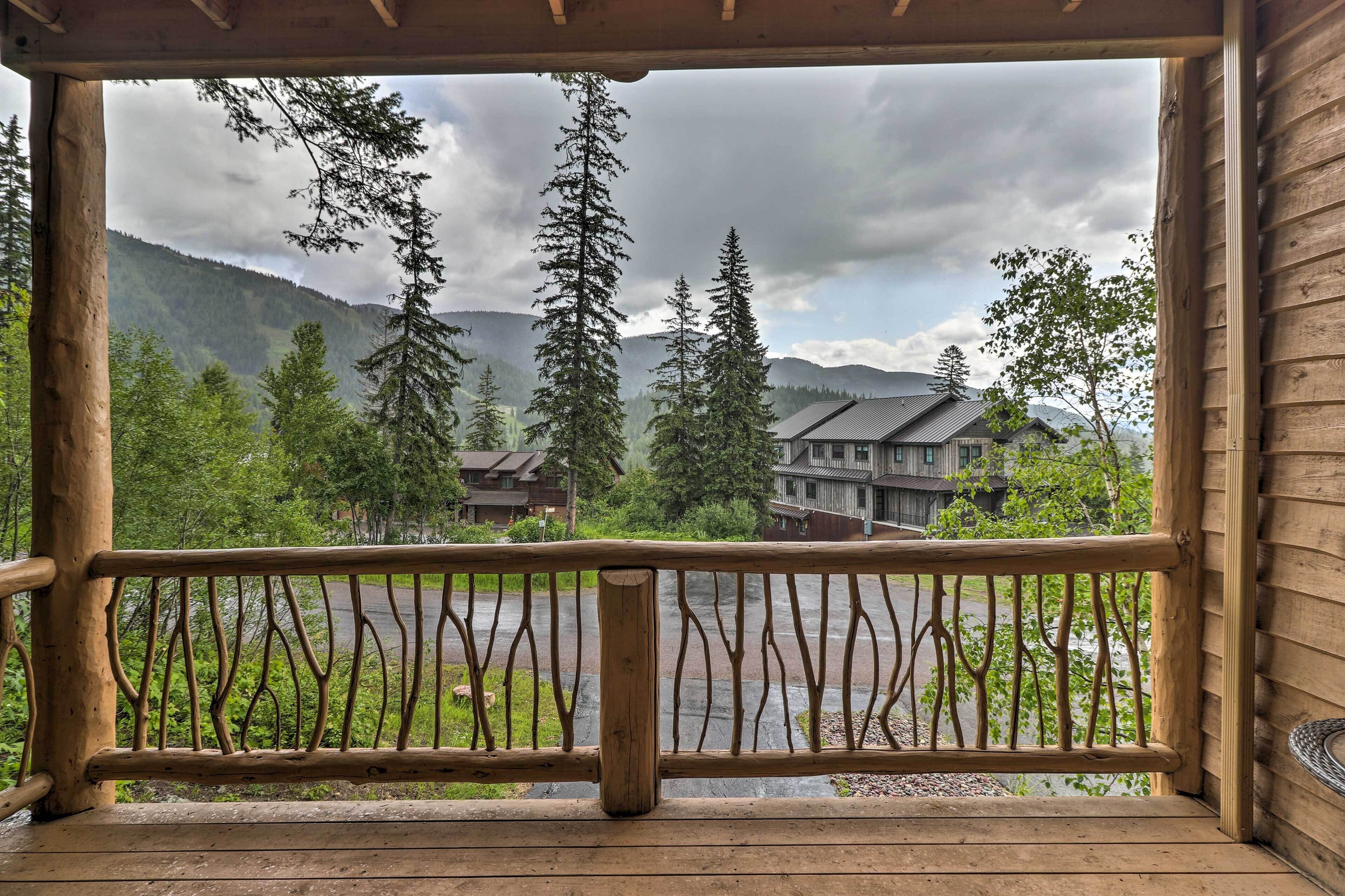 A wooden balcony with a view of a mountain and a building.