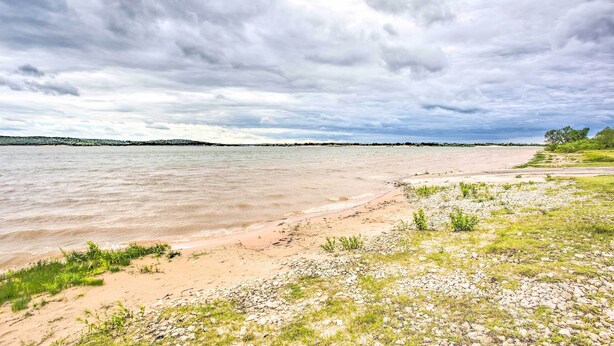A beach with a sandy shore and grassy areas.