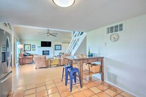 A spacious living area with a kitchen, dining table, and a staircase leading to an upper level. - Sanders Island View Home Steps to Lake Texoma (Kingston)