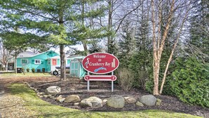 Willkommensschild für Cranberry Bay, im Hintergrund ein Haus und Bäume.