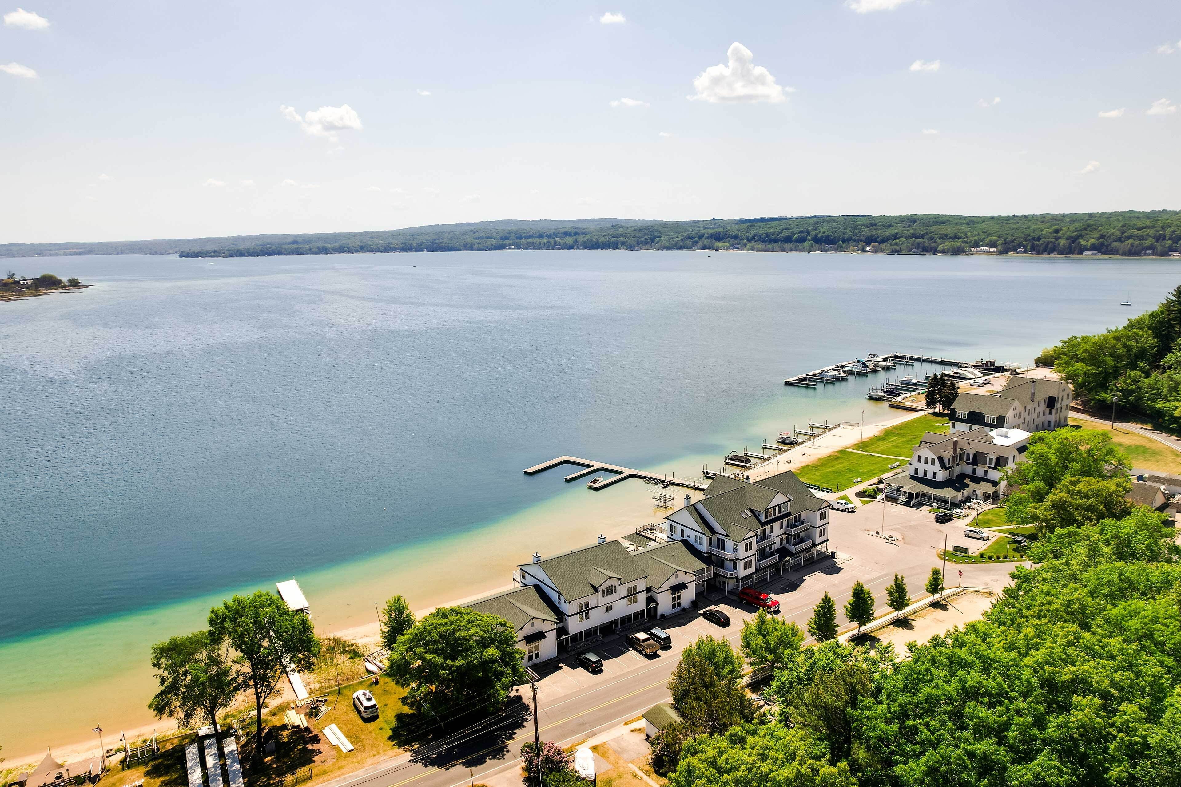 A lakeside hotel with a dock, parking area, and a view of the lake.