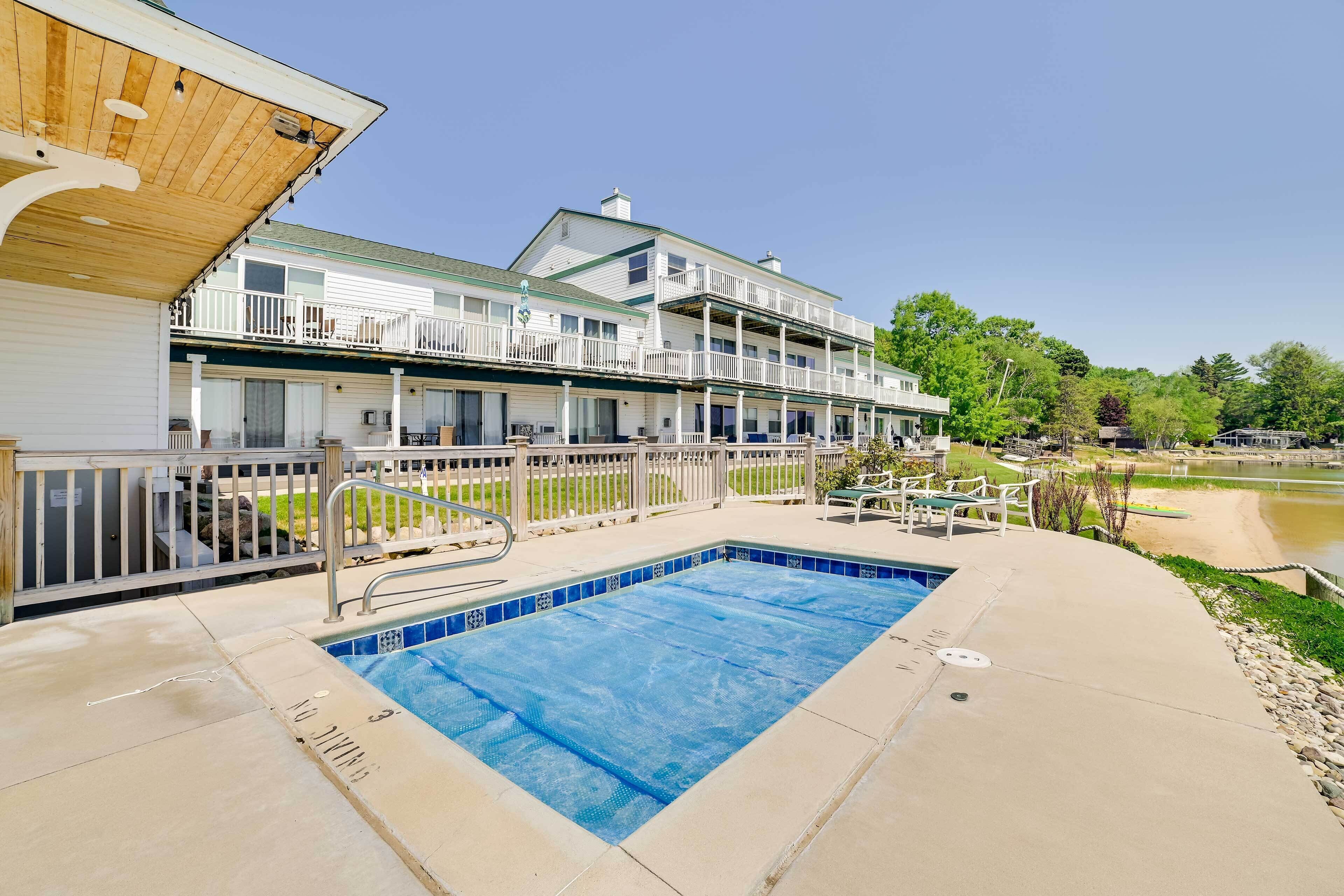 A two-story building with a swimming pool and outdoor seating.