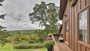 Une terrasse en bois agrémentée de plantes en pot et offrant une vue sur un paysage luxuriant.