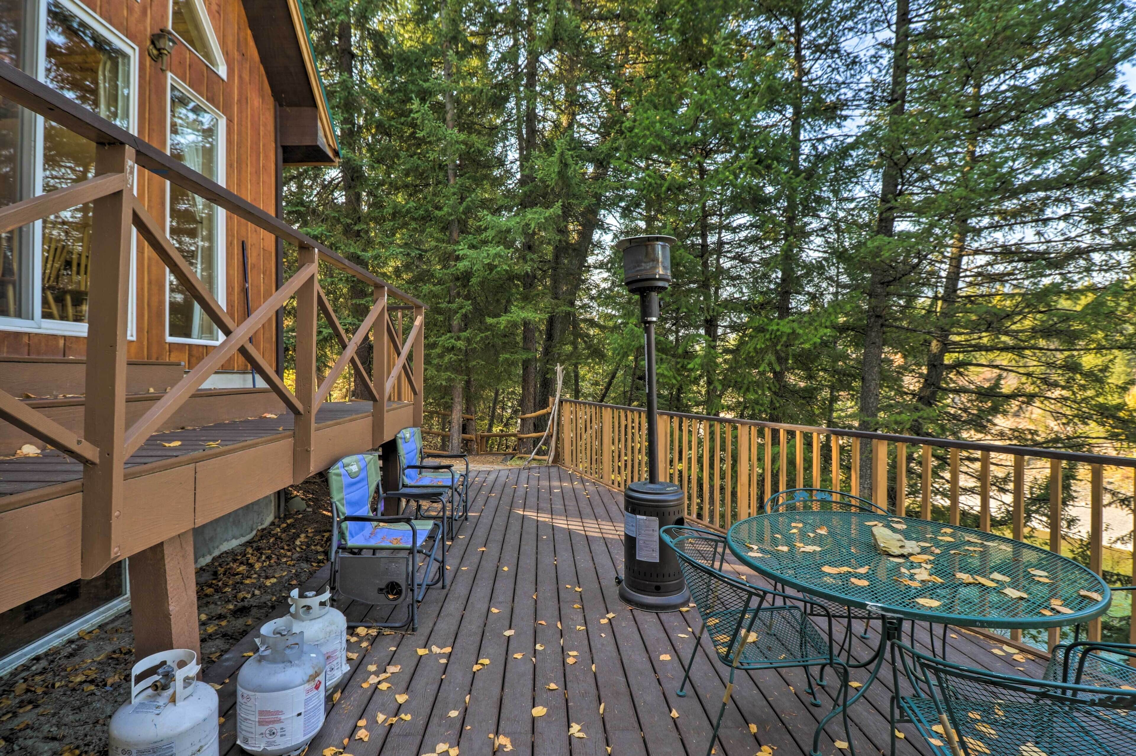 A wooden deck with outdoor seating, a table, and gas cylinders.