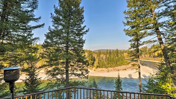A deck with a view of a river and forest. - Riverfront Hungry Horse House With Large Deck! (Hungry Horse)