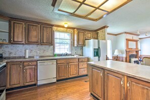 A kitchen with wooden cabinets, a dishwasher, and a refrigerator.