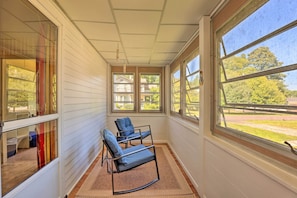 A sunroom with two blue chairs, large windows, and a view of the outside. - Walk to Beach, Marina & Town! Lake Ontario Getaway (Sodus Point)
