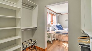 A bedroom with a bed, a nightstand, and a window with curtains. - Secluded Bonanza Home w/ Antique Furnishings (Bonanza)