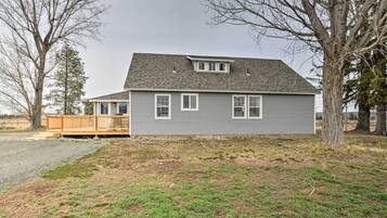 A single-story house with a grey exterior and a wooden deck.