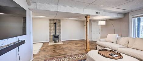 A modern living room with a fireplace, a sofa, and a wooden floor.