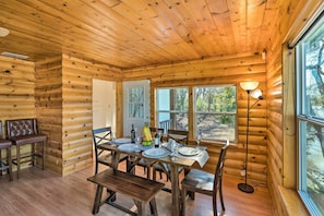 L’intérieur d’un chalet en bois comprend une table à manger pour quatre personnes, un banc et un canapé.