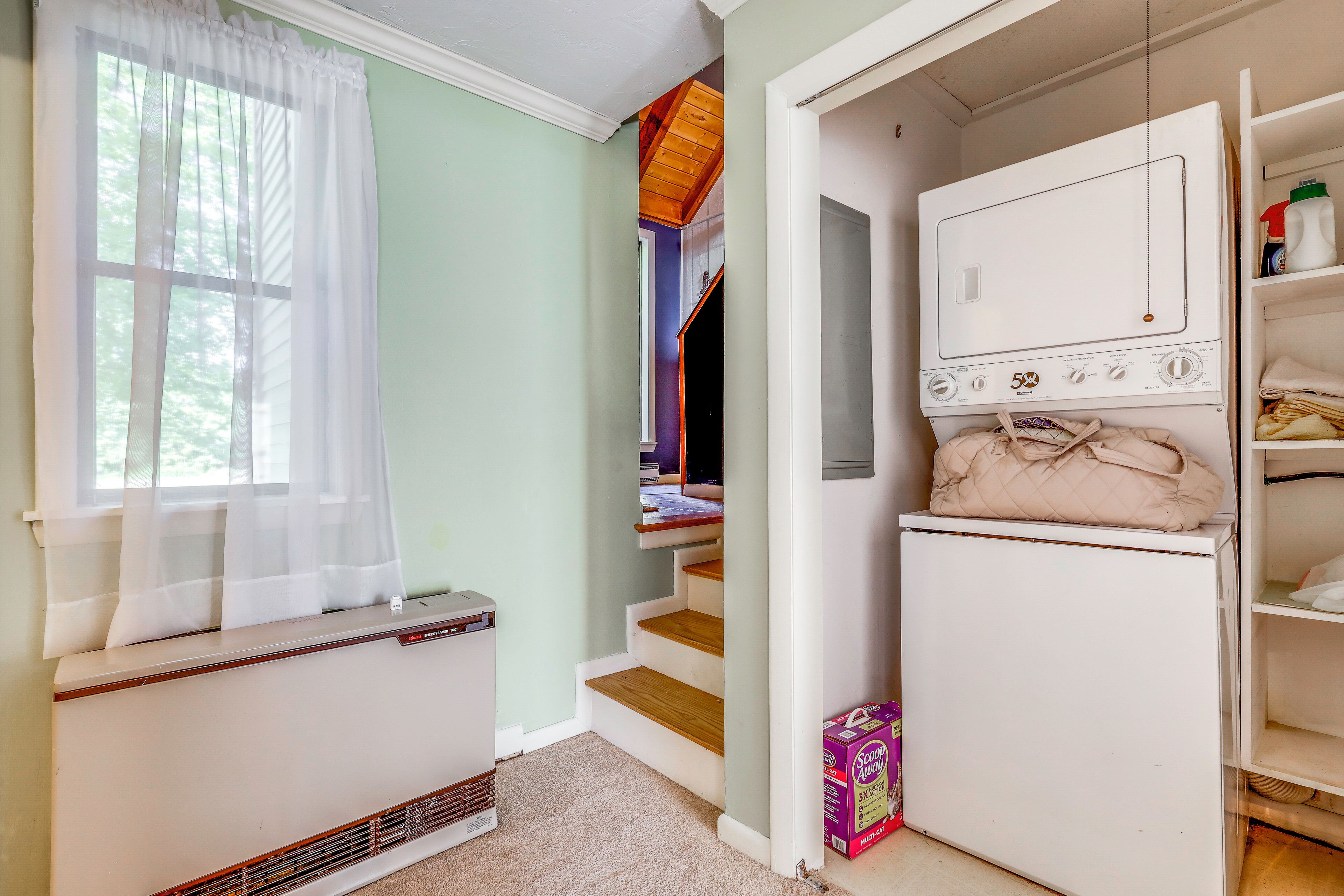 A laundry room with a washing machine, a dryer, and a radiator.