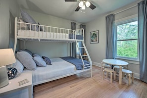 A bunk bed room with a desk, a small table, and a window with curtains. - Benton Harbor 'gracie Cottage' w/ Hot Tub + Yard! (Benton Harbor)