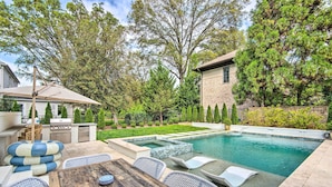 A backyard with a swimming pool, outdoor furniture, and a barbecue area. - Stunning Charlotte Home: Private Pool! (Charlotte)