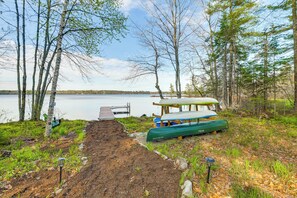 A lakeside campsite with a dock, a covered picnic table, and a canoe. - Waterfront Davis Pond Cabin w/ Dock + Kayaks! (Holden)