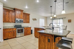Enjoy cooking in this well-equipped kitchen with a central island, stainless steel oven, and ample workspace.