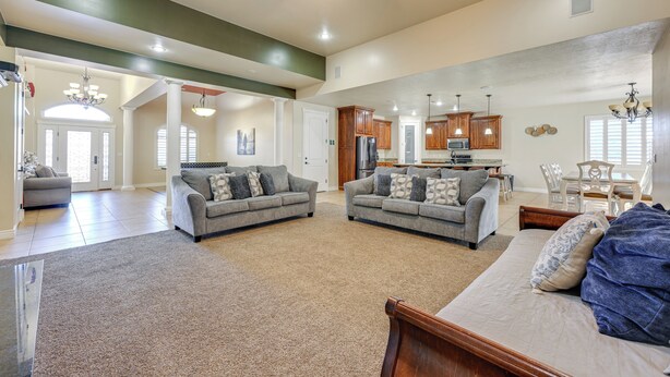 A spacious living area with two sofas, a bed, and a kitchen in the background. - Utah Retreat w/ Heated Pool, Grill & Fire Pit! (Hurricane)