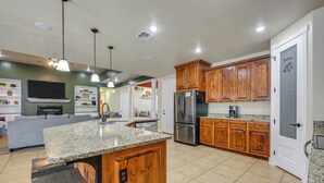 A spacious kitchen with granite countertops, wooden cabinets, and stainless steel appliances. - Utah Retreat w/ Heated Pool, Grill & Fire Pit! (Hurricane)